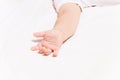 Little infant hand laying on the bed white sheet Royalty Free Stock Photo