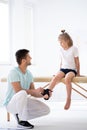Little injure girl on massage table exercising with young male doctor Royalty Free Stock Photo