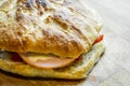 Little italian focaccia bread stuffed with turkey ham, red bell peppers, cheese and red onions on wooden cutting board Royalty Free Stock Photo