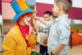 Little joyful boy touches red clown`s nose