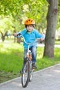 Little kid in blue jacket is cycling