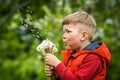 Little kid boy blowing on dandelion. Future generation. Windmills. Renewable energies and sustainable resources - wind