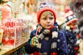 Little kid boy with candy cane stand on Christmas market Royalty Free Stock Photo