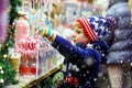 Little kid boy with candy cane stand on Christmas market Royalty Free Stock Photo