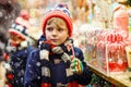 Little kid boy with candy cane stand on Christmas market Royalty Free Stock Photo