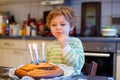 Little kid boy celebrating his birthday and blowing candles on cake Royalty Free Stock Photo