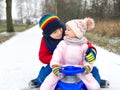 Little kid boy and cute toddler girl sitting together on sledge. Siblings, brother and baby sister enjoying sleigh ride Royalty Free Stock Photo