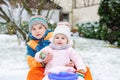 Little kid boy and cute toddler girl sitting together on sledge. Siblings, brother and baby sister enjoying sleigh ride Royalty Free Stock Photo