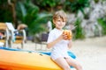 Little kid boy drinking coconut juice on tropical beach Royalty Free Stock Photo