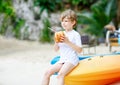 Little kid boy drinking coconut juice on tropical beach Royalty Free Stock Photo