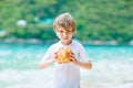 Little kid boy drinking coconut juice on tropical beach Royalty Free Stock Photo