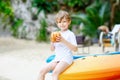 Little kid boy drinking coconut juice on tropical beach Royalty Free Stock Photo