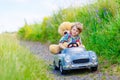 Little kid boy driving big toy car with a bear, outdoors. Royalty Free Stock Photo