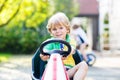 Little kid boy driving pedal car in summer garden Royalty Free Stock Photo