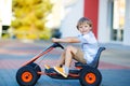 Little kid boy driving pedal race car in summer Royalty Free Stock Photo