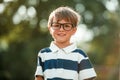 little kid boy in eyeglasses with big backpack. School, kid, rucksack. Cheerful smiling little boy opens his mouth in Royalty Free Stock Photo