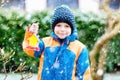 Little kid boy hanging bird house on tree for feeding in winter Royalty Free Stock Photo