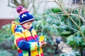 Little kid boy hanging bird house on tree for feeding in winter Royalty Free Stock Photo