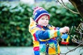 Little kid boy hanging bird house on tree for feeding in winter Royalty Free Stock Photo