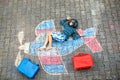 Little kid boy having fun with with airplane picture drawing with colorful chalks on asphalt. Child painting with chalk