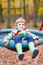 Little kid boy having fun on autumn playground