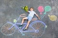 Little kid boy having fun with bicycle chalks picture on ground Royalty Free Stock Photo