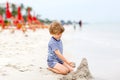 Little kid boy having fun with building sand castles Royalty Free Stock Photo