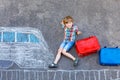Little kid boy having fun with fast train picture drawing with colorful chalks on asphalt. Child painting with chalk and Royalty Free Stock Photo