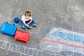 Little kid boy having fun with fast train picture drawing with colorful chalks on asphalt Royalty Free Stock Photo