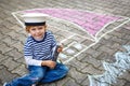 Little kid boy having fun with ship picture drawing with chalk Royalty Free Stock Photo