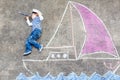 Little kid boy having fun with ship picture drawing with chalk Royalty Free Stock Photo