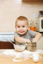 Little kid boy helps mother to cook ginger biscuit. Happy family mom and child in weekend morning at home. Relationship.