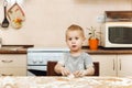 Little kid boy helps mother to cook ginger biscuit. Happy family mom and child in weekend morning at home. Relationship.