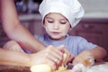 Little kid boy helps mother to cook pizza. Happy family mom and child in weekend morning at home. Preparing the dough for baking Royalty Free Stock Photo