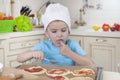 Little kid boy helps mother to cook pizza. Happy family mom and child in weekend morning at home. Relationship Royalty Free Stock Photo