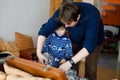 Little kid boy and his dad taking down holiday decorations from Christmas tree. Father on background. Family after Royalty Free Stock Photo