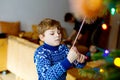 Little kid boy and his dad taking down holiday decorations from Christmas tree. Father on background. Family after Royalty Free Stock Photo