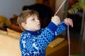 Little kid boy and his dad taking down holiday decorations from Christmas tree. Father on background. Family after Royalty Free Stock Photo