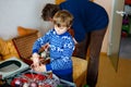 Little kid boy and his dad taking down holiday decorations from Christmas tree. Father on background. Family after Royalty Free Stock Photo