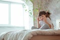 Little kid boy laying in bed, relaxing with his kitten. Happy child with pet sitting on the bed Royalty Free Stock Photo