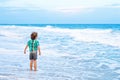 Little kid boy looking on sunset on the beach of ocean Royalty Free Stock Photo