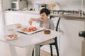 Little kid boy making pizza sitting at the table on the kitchen. Children helping in cooking lifestyle image Royalty Free Stock Photo