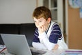 Little kid boy making school homework on computer notebook. Happy healthy child searching information on internet. New Royalty Free Stock Photo