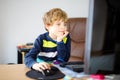 Little kid boy making school homework on computer notebook. Happy healthy child searching information on internet. New Royalty Free Stock Photo