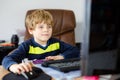 Little kid boy making school homework on computer notebook. Happy healthy child searching information on internet. New Royalty Free Stock Photo