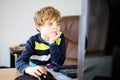 Little kid boy making school homework on computer notebook. Happy healthy child searching information on internet. New Royalty Free Stock Photo
