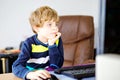 Little kid boy making school homework on computer notebook. Happy healthy child searching information on internet. New Royalty Free Stock Photo