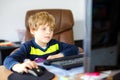 Little kid boy making school homework on computer notebook. Happy healthy child searching information on internet. New Royalty Free Stock Photo