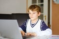 Little kid boy making school homework on computer notebook. Happy healthy child searching information on internet. New Royalty Free Stock Photo