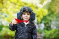 Little kid boy in pilot helmet playing with toy airplane